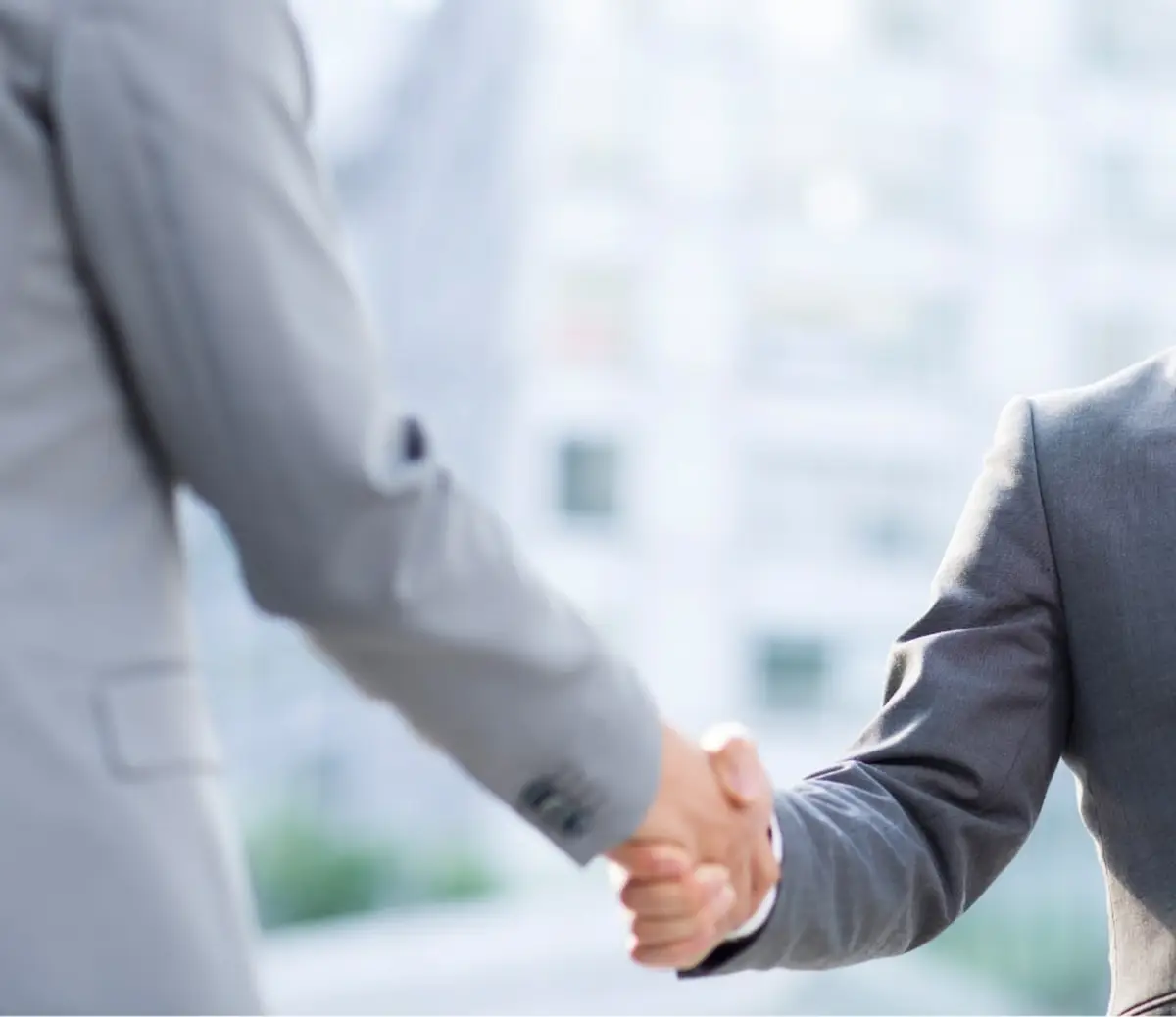 Business professionals shaking hands in formal attire